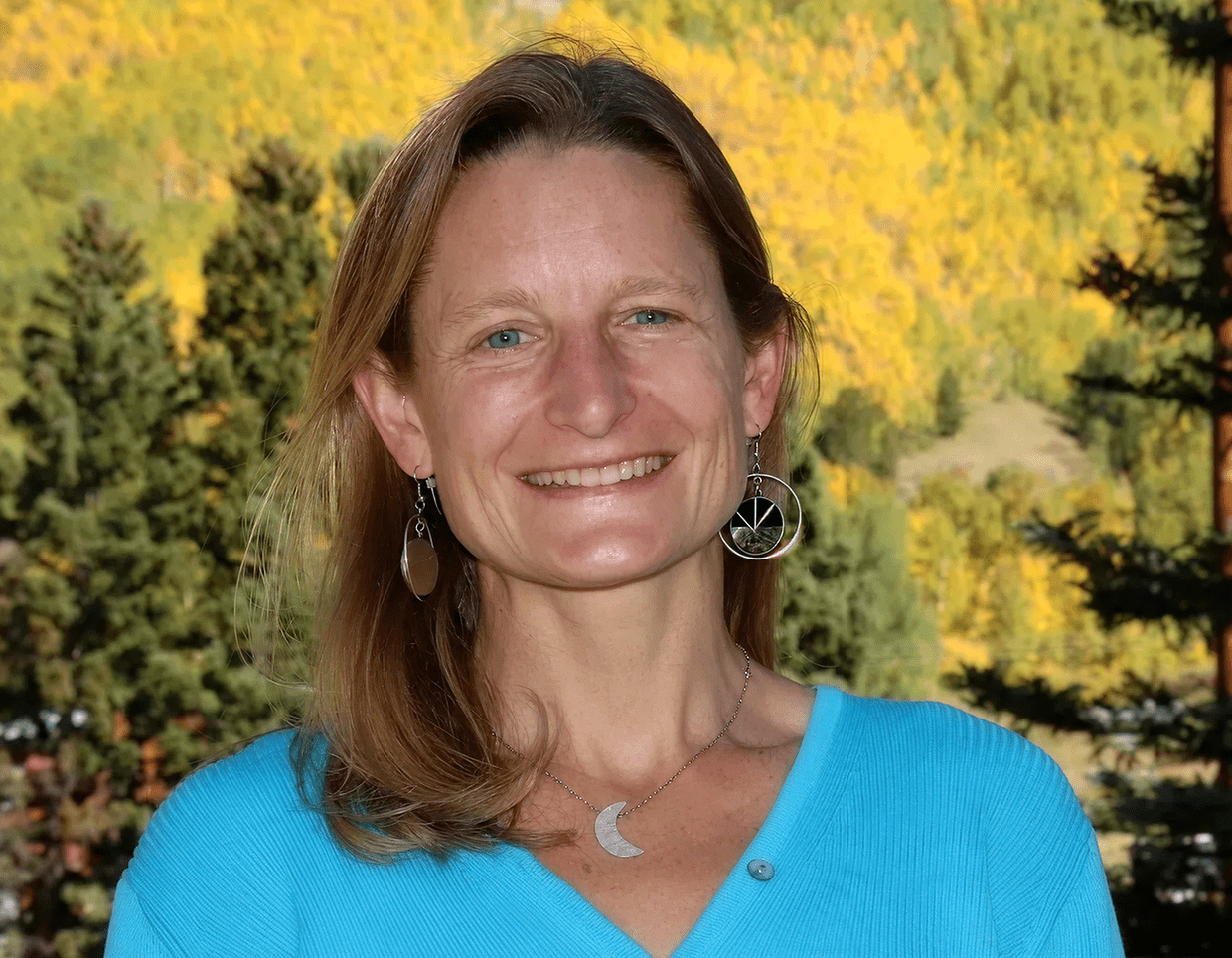 Smiling woman outdoors with autumn trees